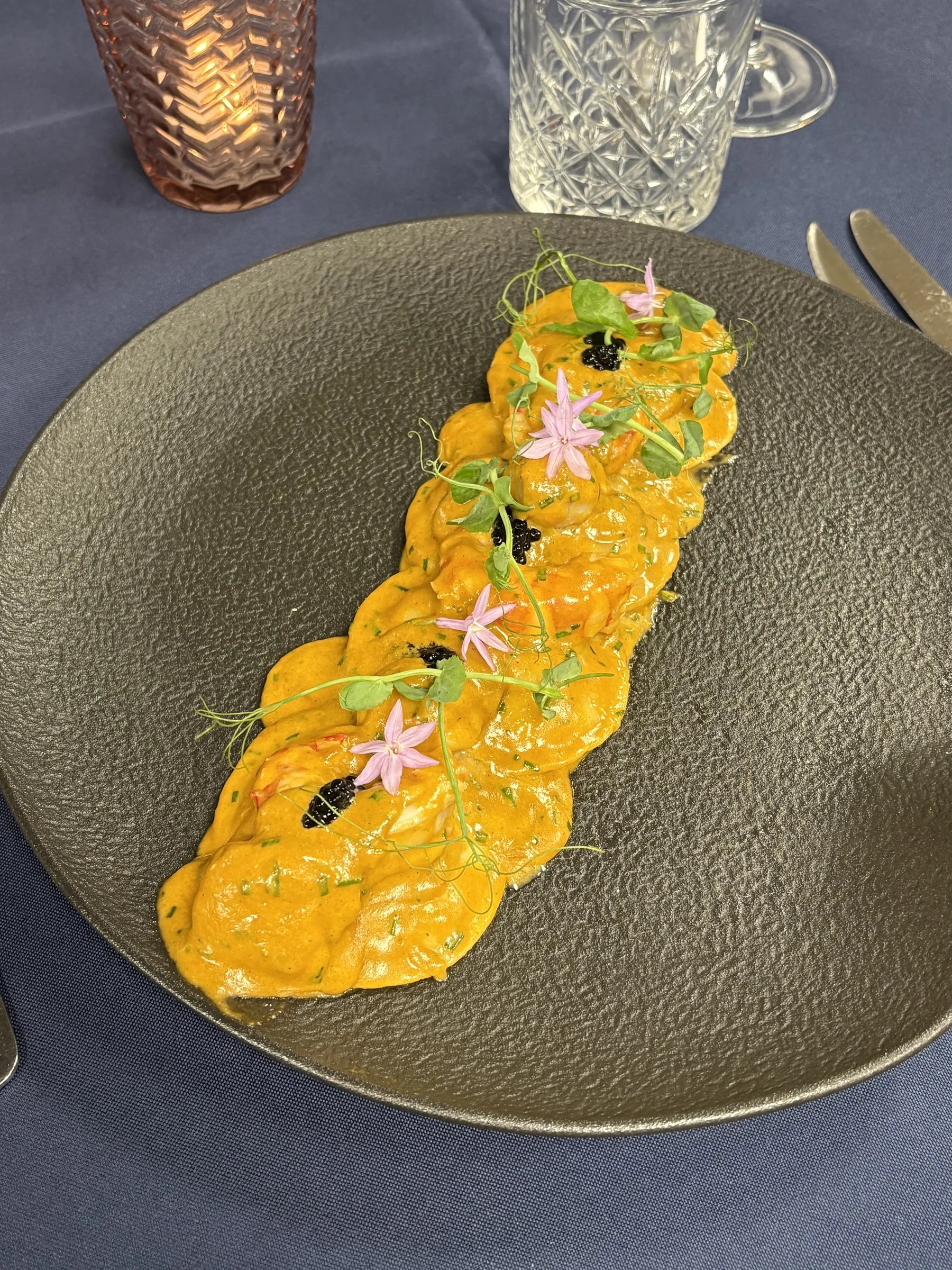 Garnelen in einer leuchtend orangen Sauce angerichtet